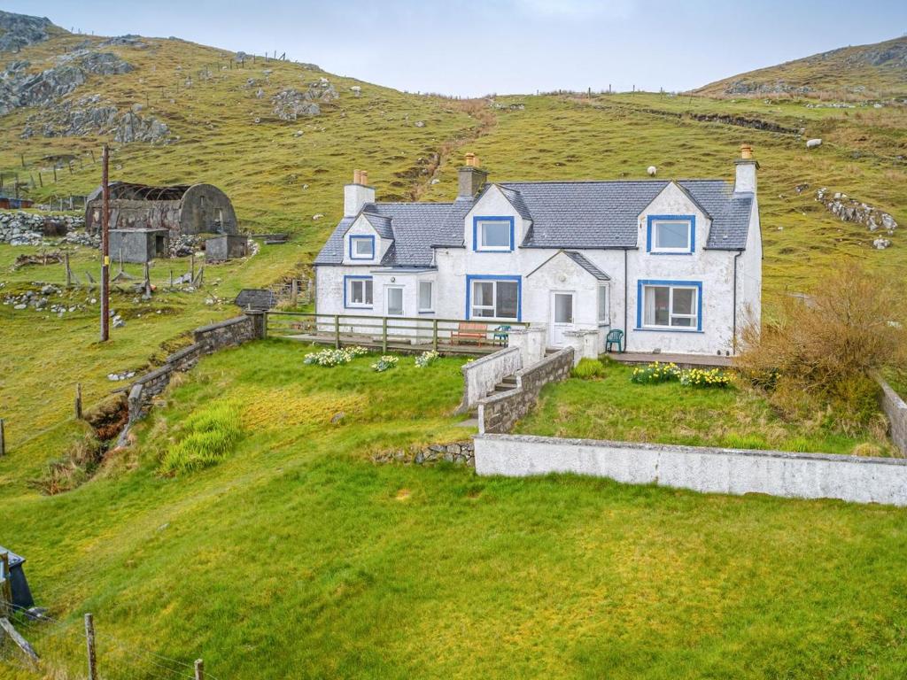 a large white house on a hill with a grass yard at The Nicolson House in Graver