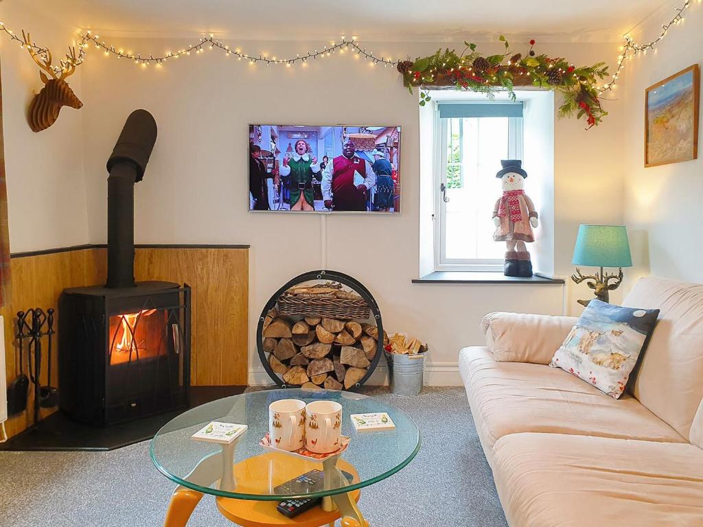 a living room with a couch and a wood stove at Christmas Cottage in Cheddar