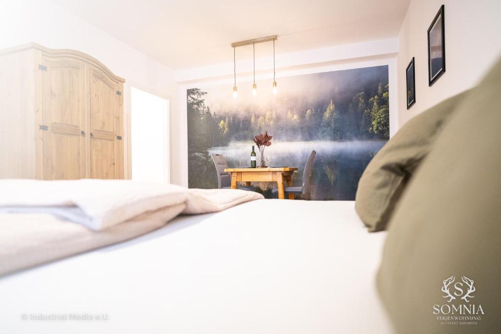 1 dormitorio con 1 cama y una pintura en la pared en Ferienwohnung Somnia - Altstadt Gmunden, en Gmunden