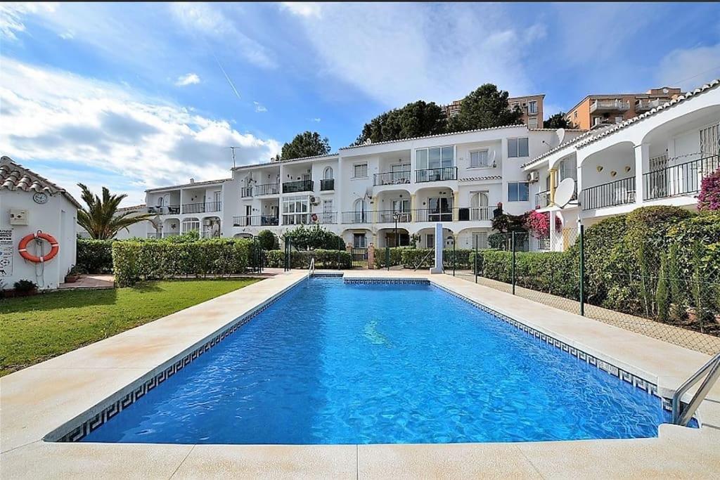 uma piscina em frente a um edifício em lux 2 kmr app Stella Blanca met zwembaden airco en zeezicht em Fuengirola