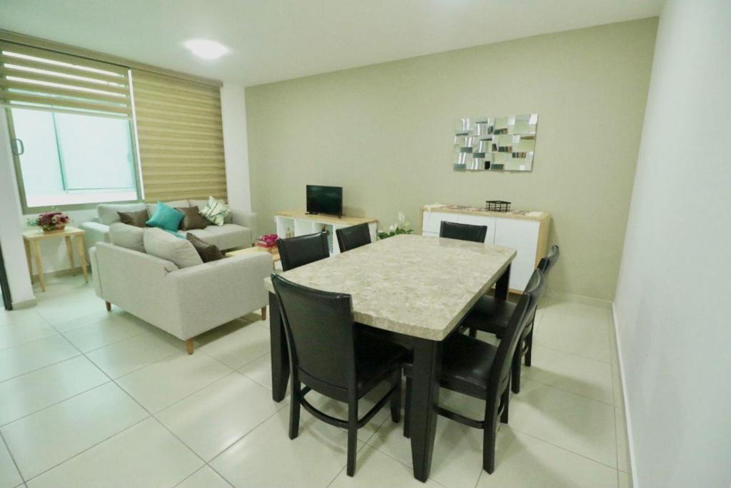 sala de estar con mesa, sillas y sofá en Shanarani Apartament, en Uruapan del Progreso