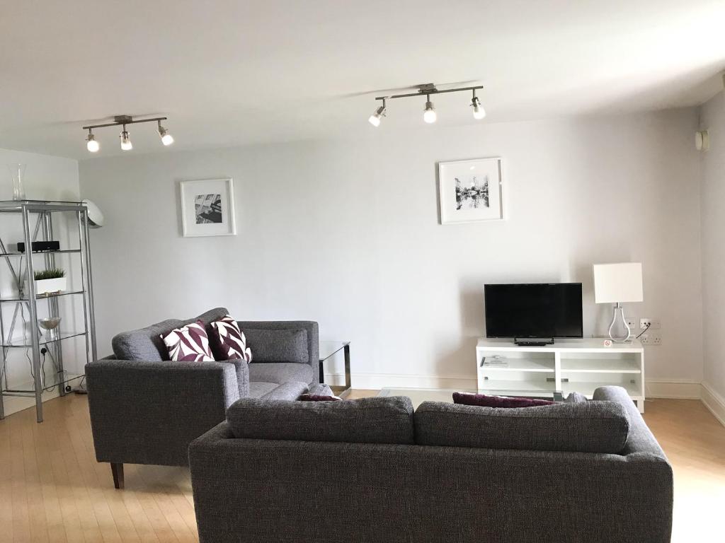 a living room with two couches and a tv at Roomspace Serviced Apartments - The Courtyard in London