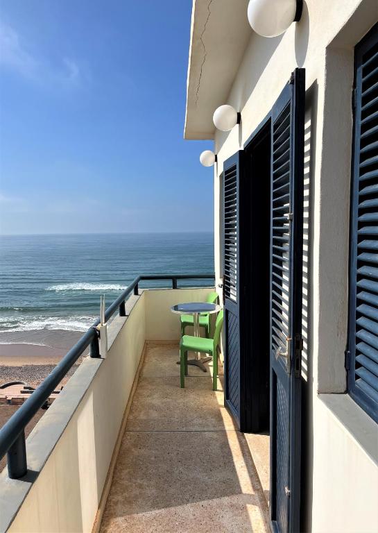 a balcony with a table and a view of the ocean at logis la marine in Sidi Ifni