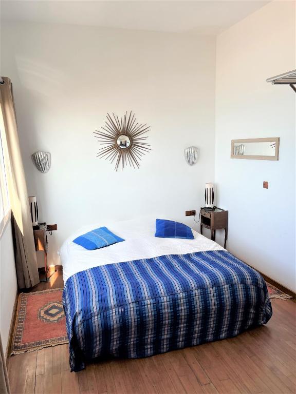 a bedroom with a bed with a blue and white comforter at logis la marine in Sidi Ifni
