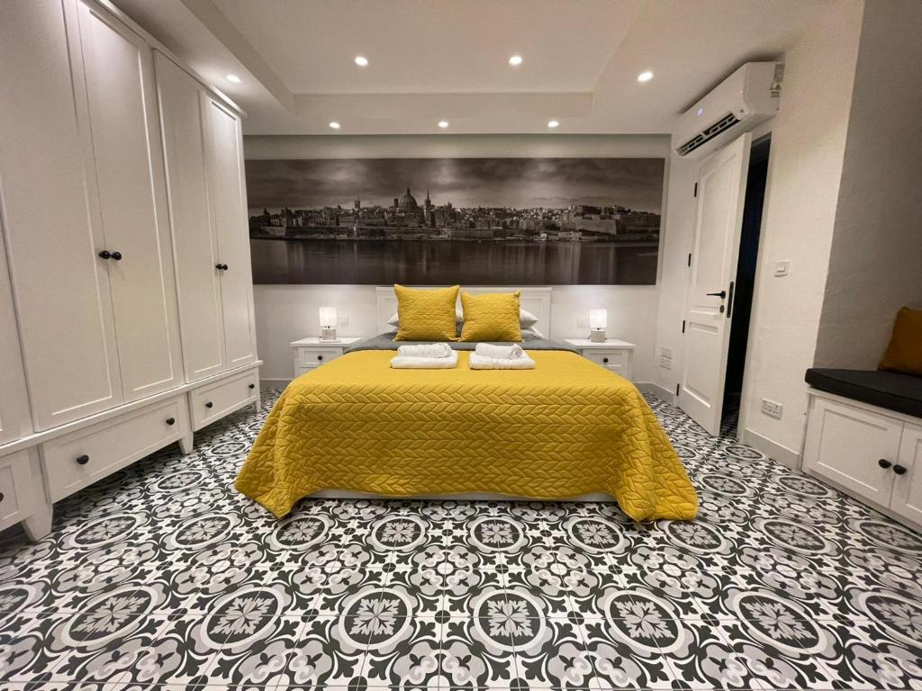 a bedroom with a bed with a yellow bedspread at Valletta Home -Dar il-Kavallier Jacques de Quiqueran in Valletta