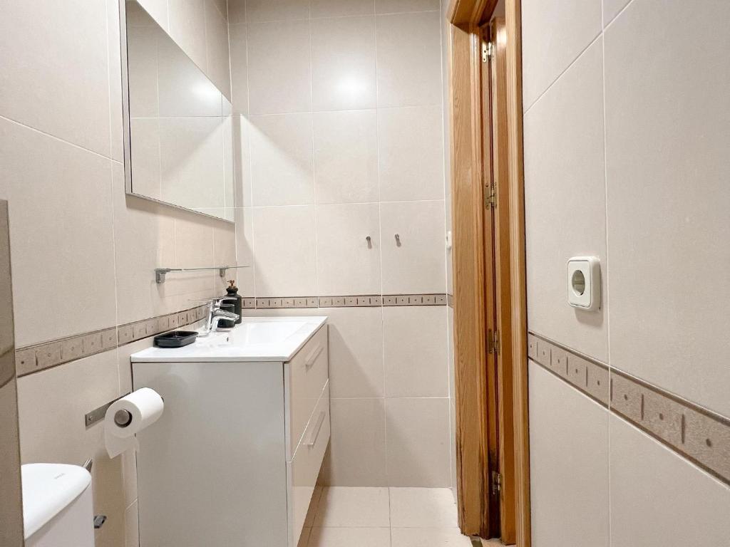 a white bathroom with a sink and a toilet at El domicilio de Fernando Garrido in Madrid