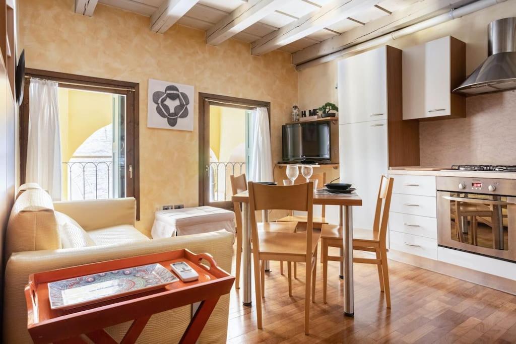 een keuken en een woonkamer met een tafel en een bank bij Residence dei Frutti in pieno centro - Il Gelso in Padua