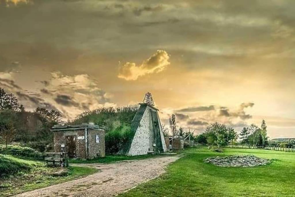 una vecchia casa in un campo con una strada sterrata di La Poudrière : lieu insolite, havre de paix a Vielsalm