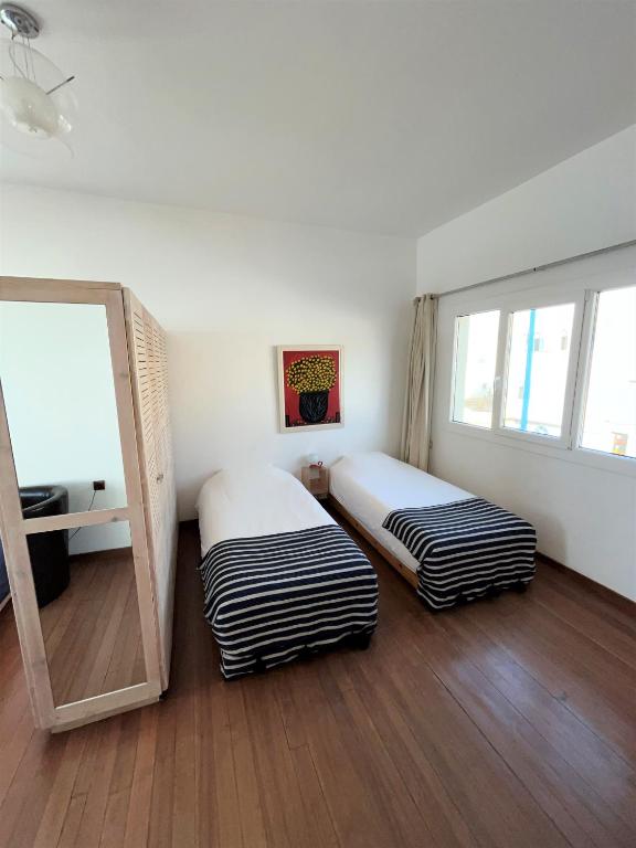 a room with two beds and a mirror in it at logis la marine in Sidi Ifni