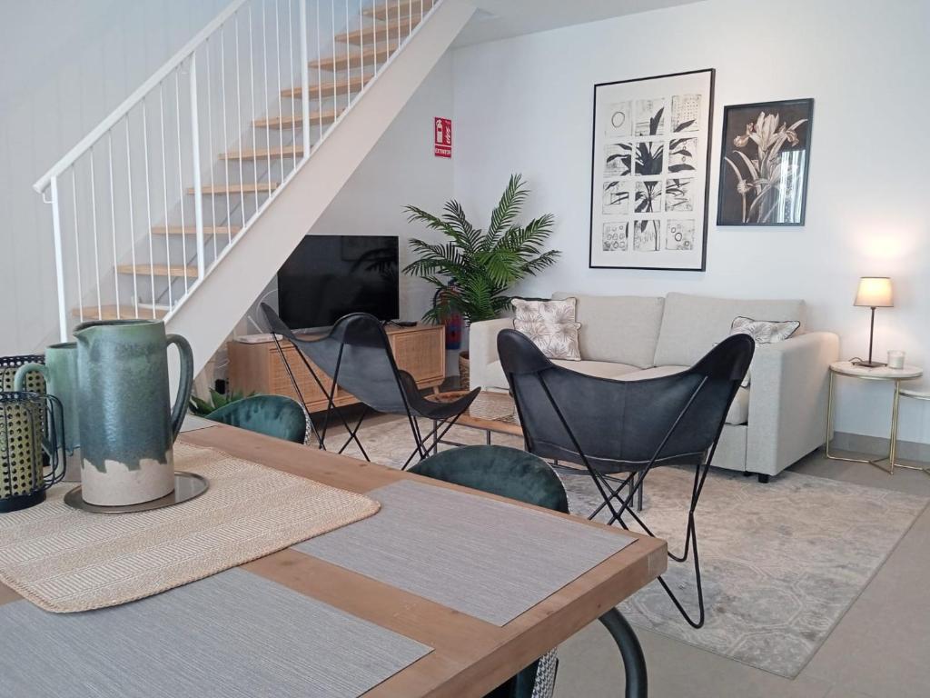un soggiorno con tavolo e sedie di LANUZA - Apartamentos Down Town Málaga Centro a Málaga