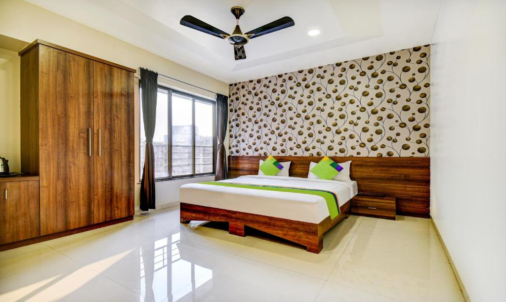 a bedroom with a bed and a window at Treebo Trend Kuber Inn in Kharadi