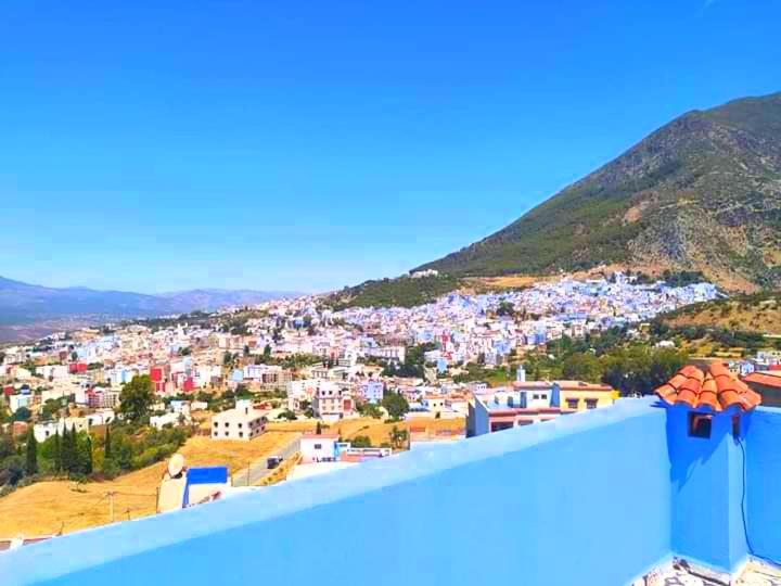 een uitzicht op de stad vanaf het dak bij Dar Achraf in Chefchaouene