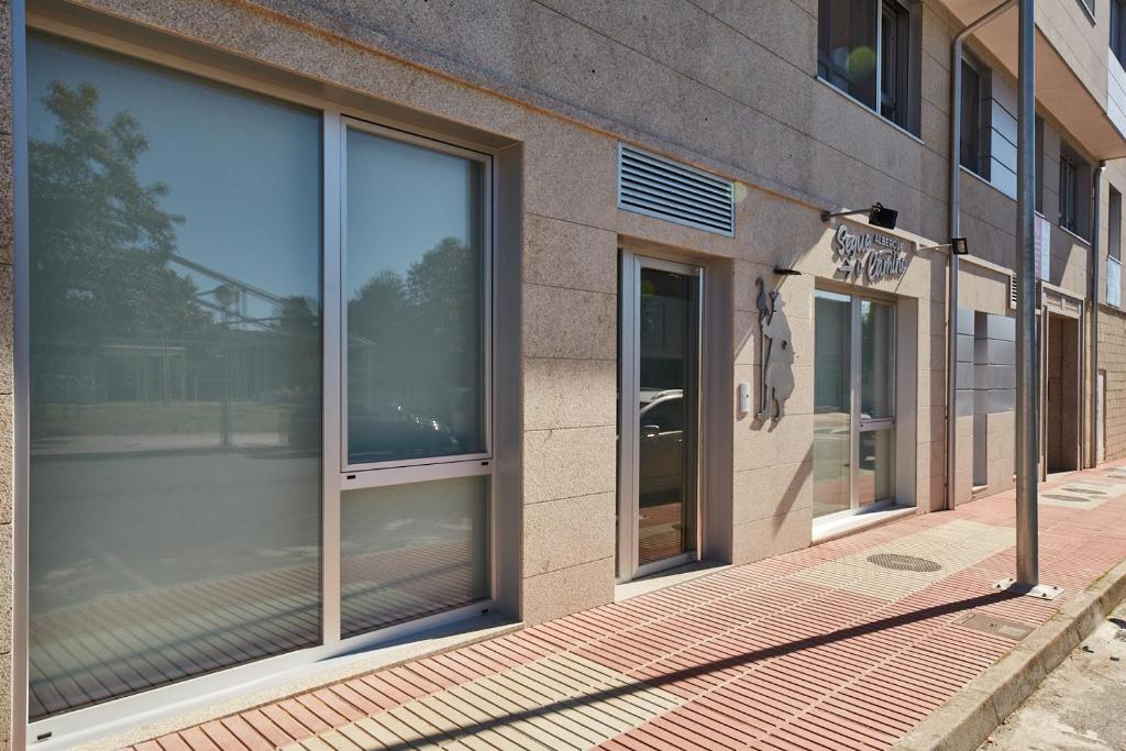 fachada de un edificio con grandes ventanas de cristal en ALBERGUE SEGUE O CAMIÑO, en Sigüeiro