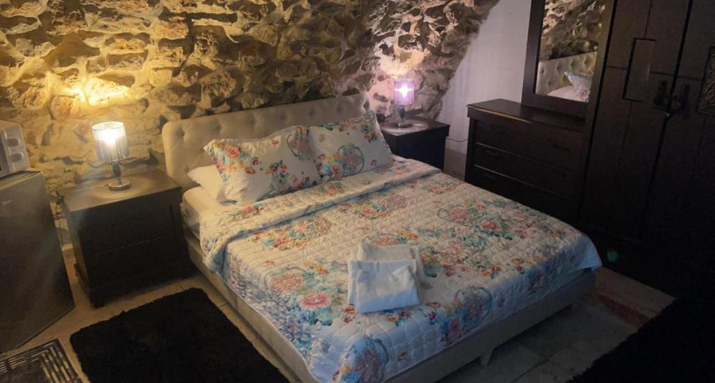 a bedroom with a bed and two night stands with lamps at Jerusalem Old City room in Yerushalayim