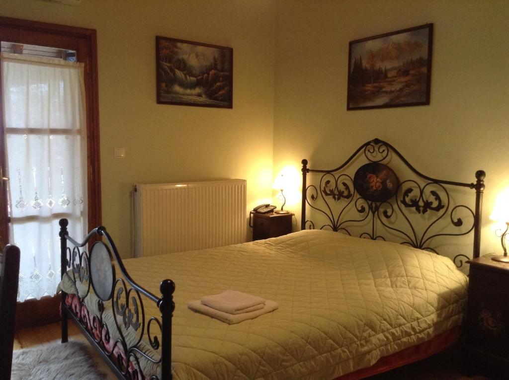 sypialnia z łóżkiem, 2 lampami i oknem w obiekcie Ξενώνας Η Φωλιά w mieście Agios Lavredios