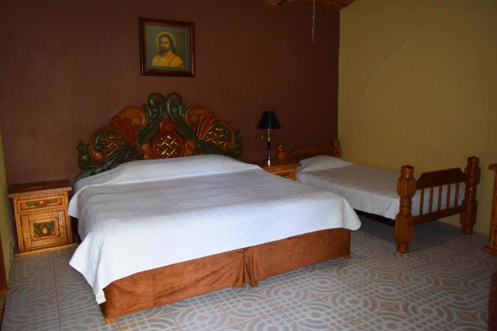1 Schlafzimmer mit 2 Betten und weißer Bettwäsche in der Unterkunft El mesón de doña Josefina in Venustiano Carranza