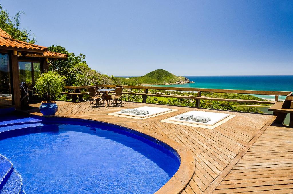 uma piscina num deque com vista para o oceano em Solar Mirador Exclusive Resort e SPA na Praia do Rosa