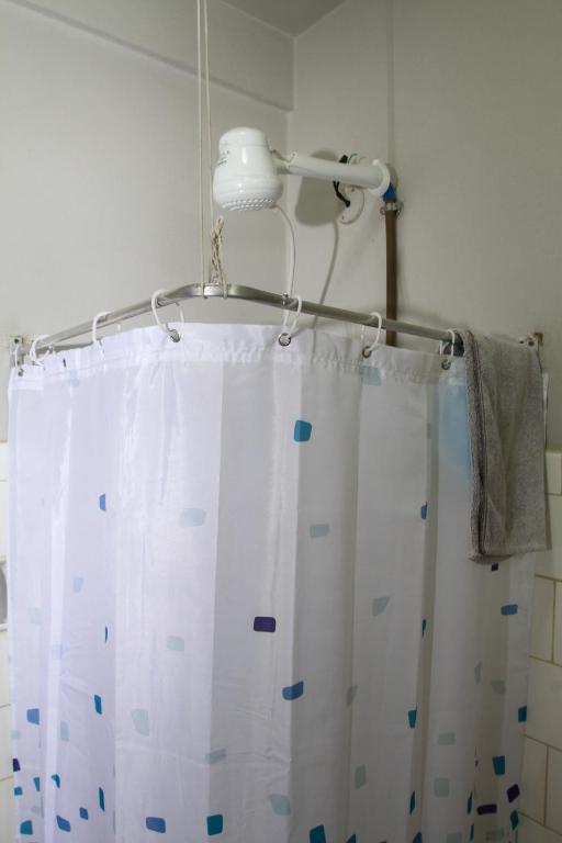 a bathroom with a shower curtain and a light at Studio no Largo da Carioca - Rio de Janeiro in Rio de Janeiro
