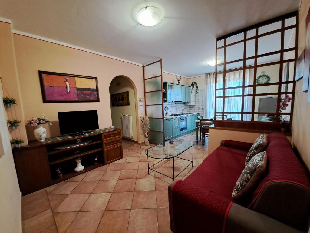 a living room with a red couch and a tv at Apartament Thermae in Bagni San Filippo