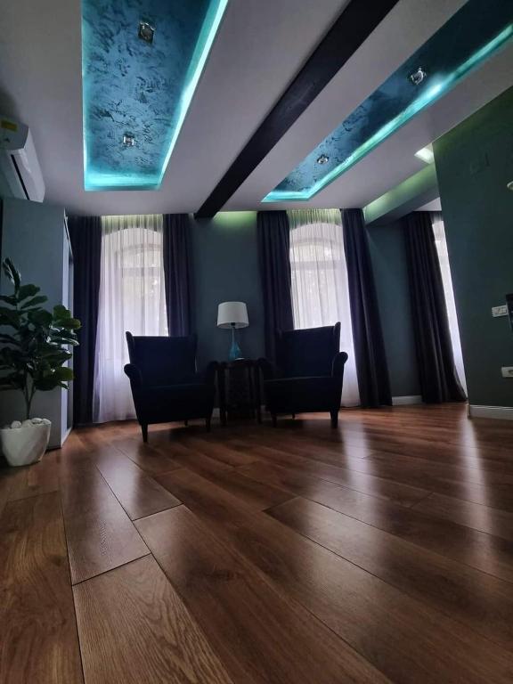 a living room with two chairs and a wooden floor at Laci lak modern apartment in Oradea