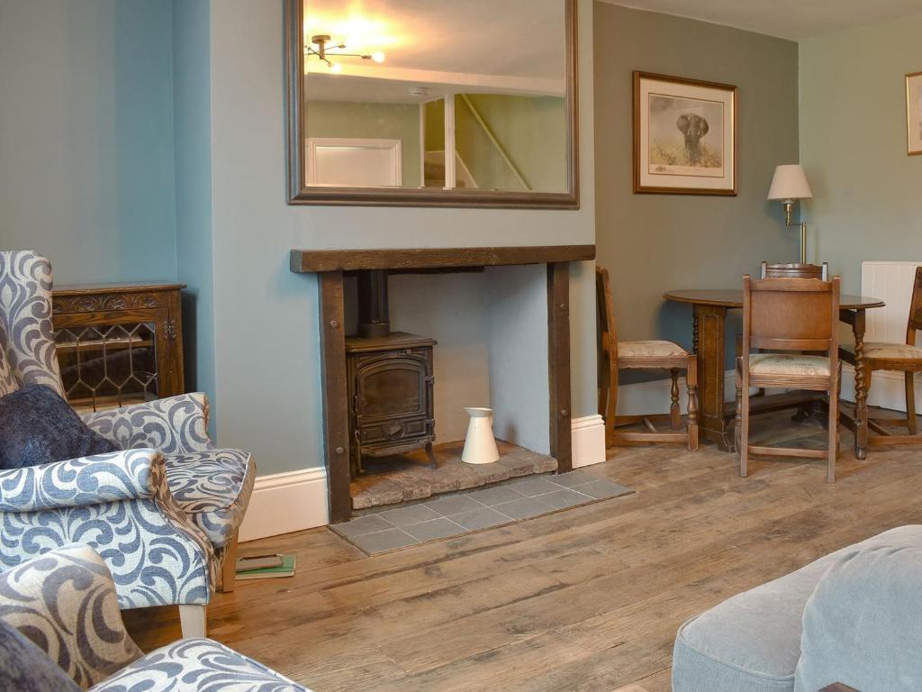 a living room with a fireplace and a mirror at Dusty House in Ashbourne