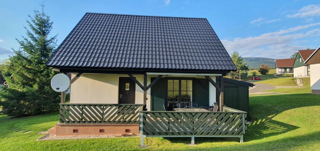 a small house with a black roof at Relax Chalet in Cerny Dul