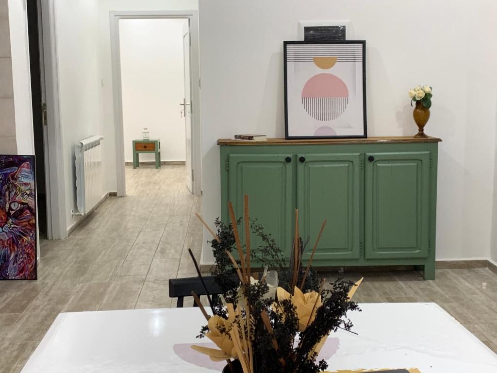 布米爾達斯的住宿－Le Rocher，一间设有绿色橱柜和鲜花桌的房间