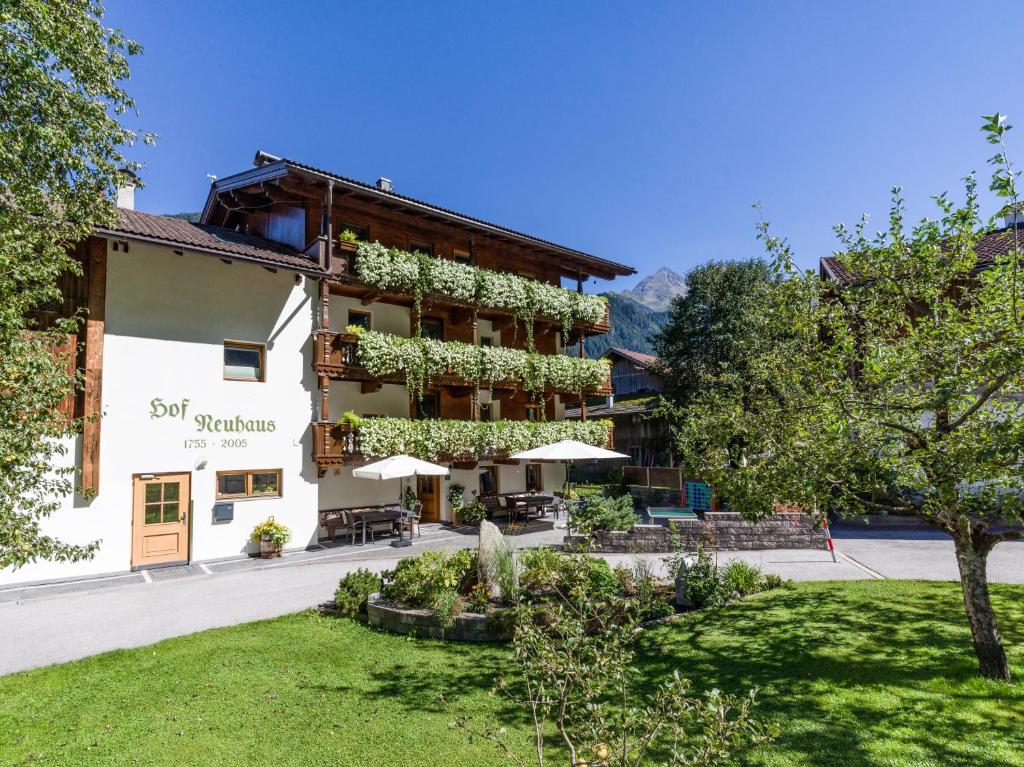 a hotel with a garden in front of it at Hof Neuhaus in Mayrhofen