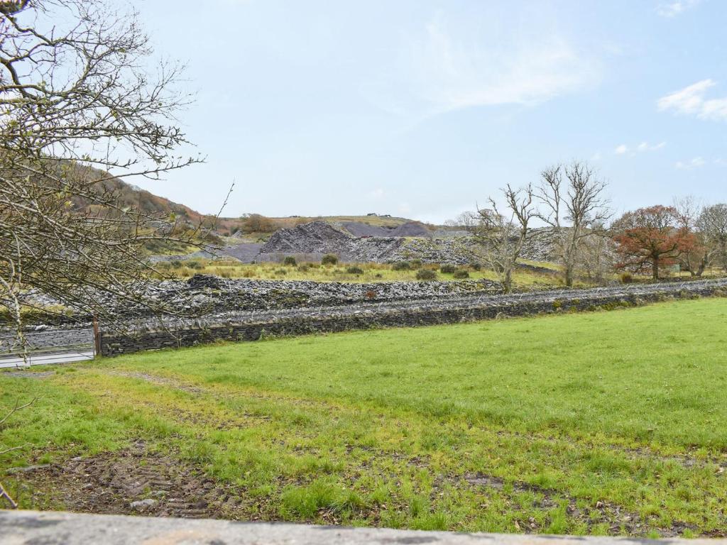 uma parede de pedra num campo com relva verde em Ty Mawr 2 - Uk36549 em Nantlle