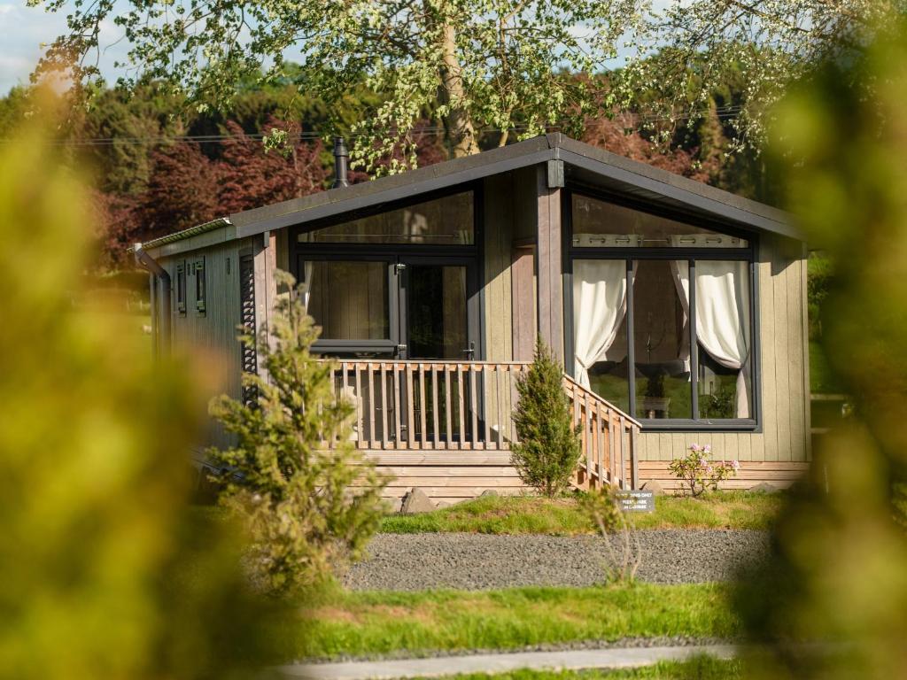 eine kleine Hütte mit einer Veranda im Garten in der Unterkunft Lodge 2 - Kinnoull in Perth