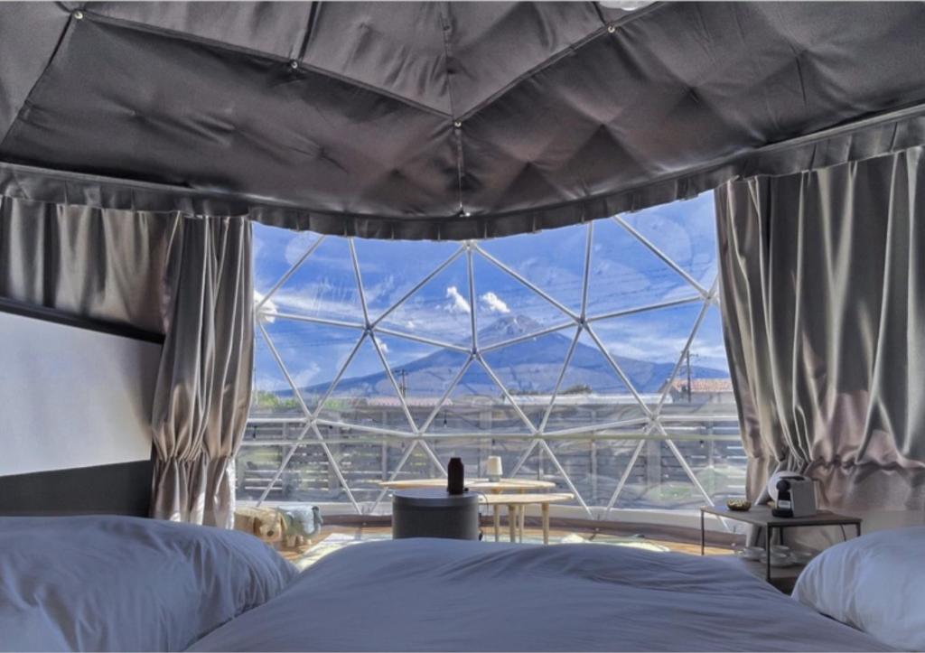 ein Schlafzimmer mit einem Himmelbett und einem großen Fenster in der Unterkunft Nekoana Glamping - Vacation STAY 39635v in Fujikawaguchiko