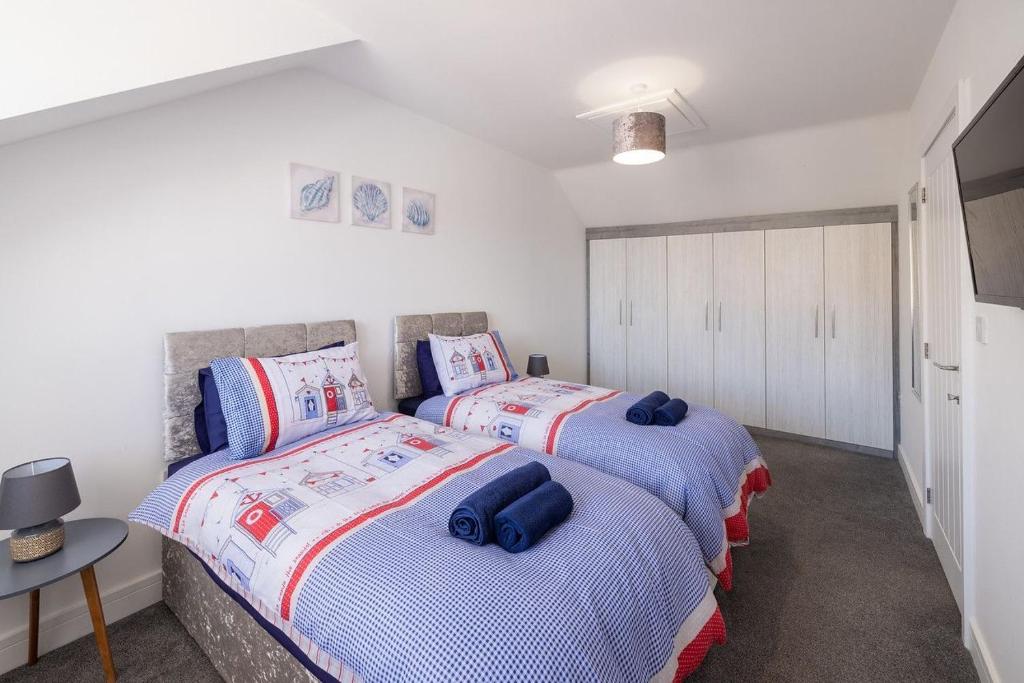 two twin beds in a room with white walls at Cleethorpes Holiday Home SLEEPS 6 in Cleethorpes