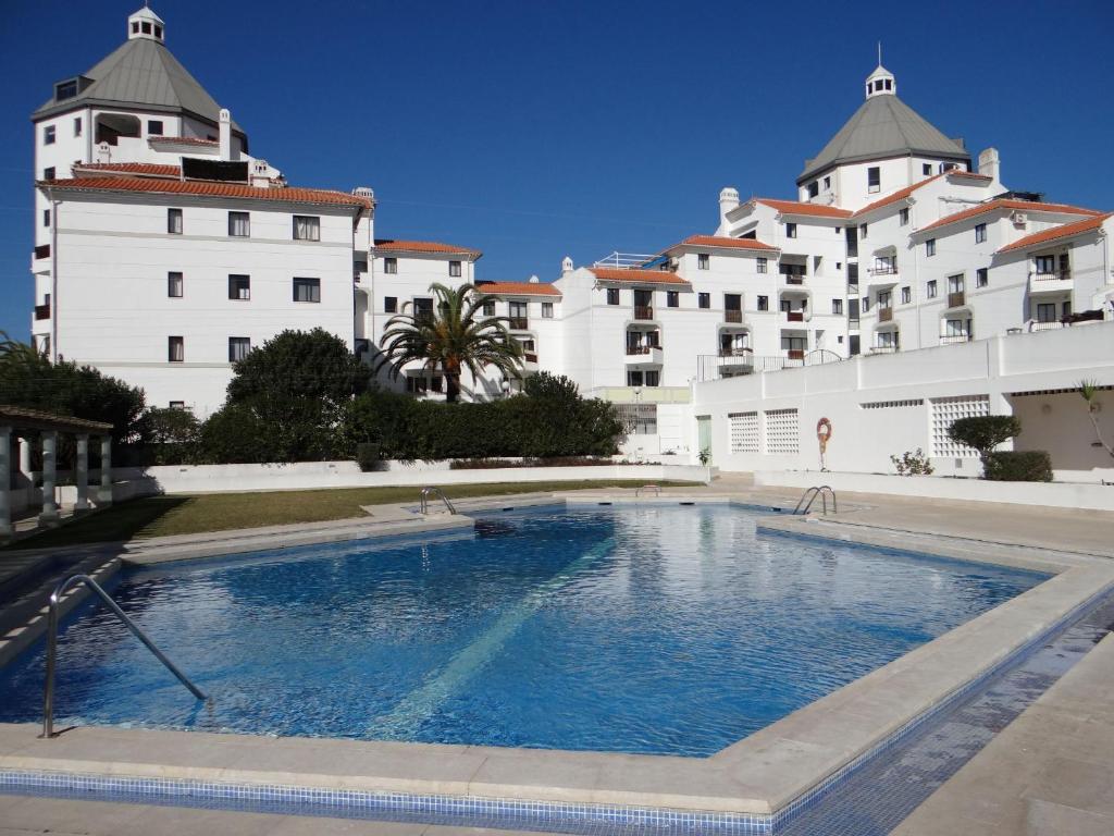 a large swimming pool in front of a building at Porto Marina @Vilamoura in Vilamoura