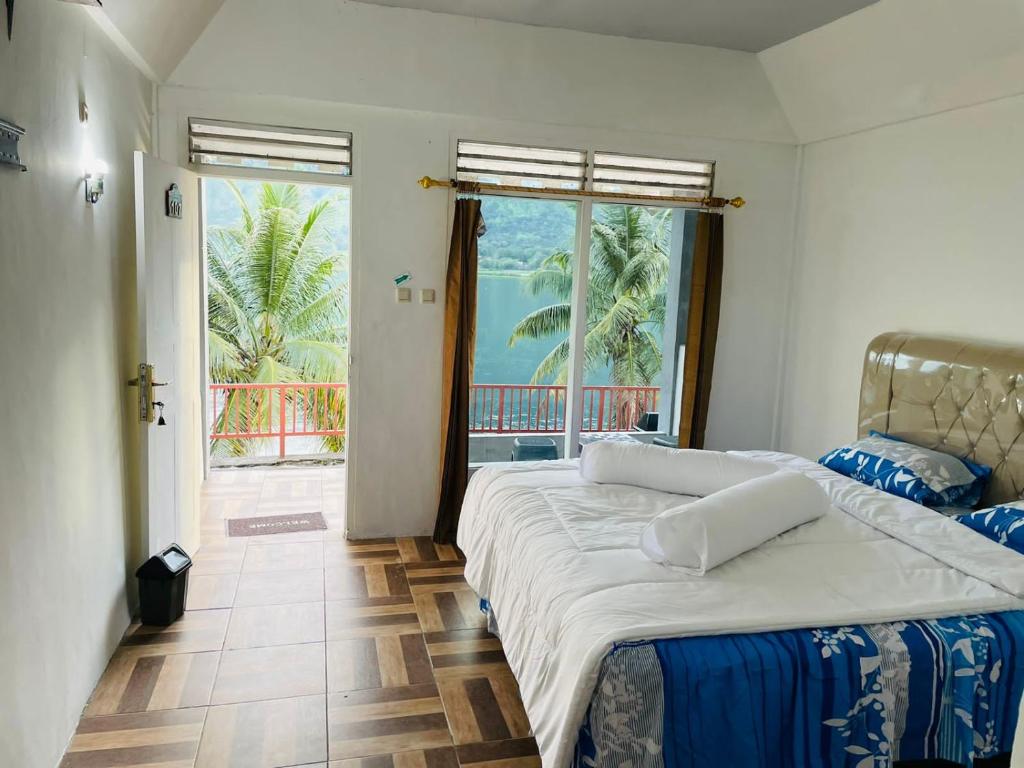 a bedroom with two beds and a view of the ocean at Vandu's View Guest house & Restaurant in Tuk Tuk