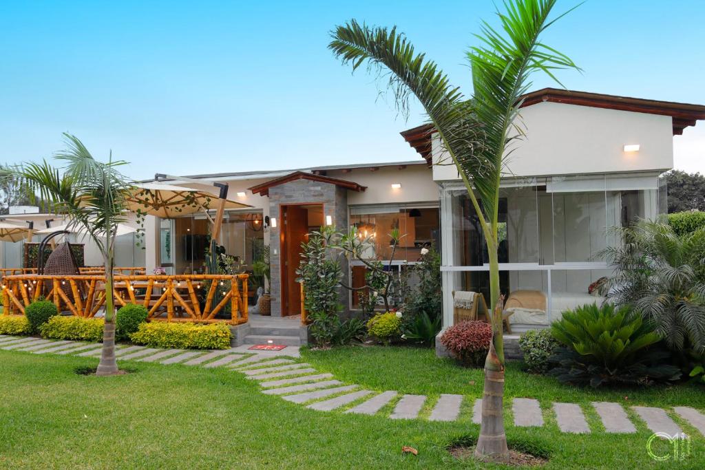 a house with a palm tree in the yard at Kuyayky Lodge in Lima