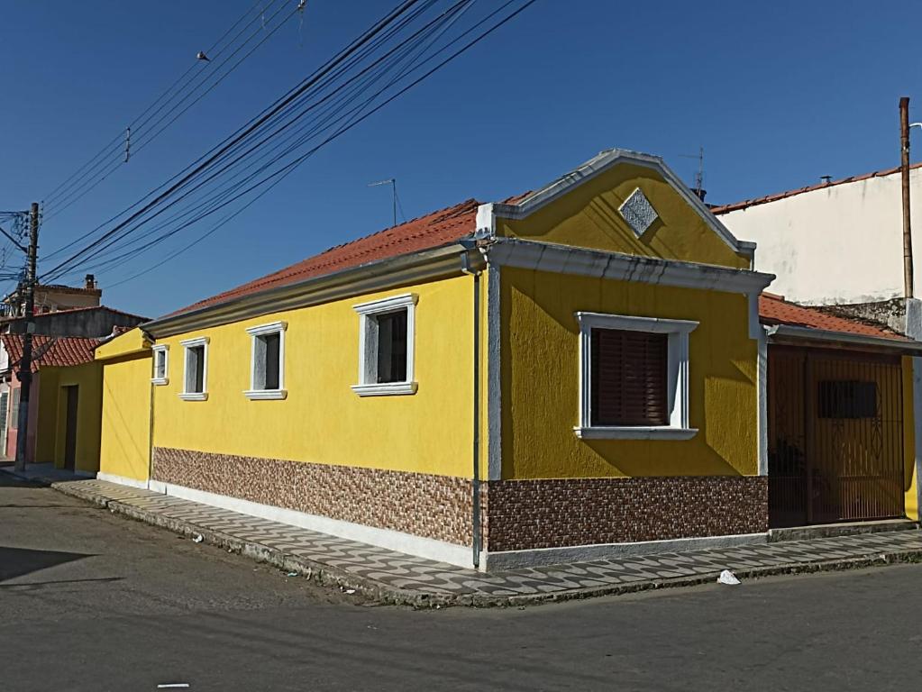 un edificio amarillo al lado de una calle en Casa a 5 minutos a pé da Basílica e da feira em Aparecida, en Aparecida