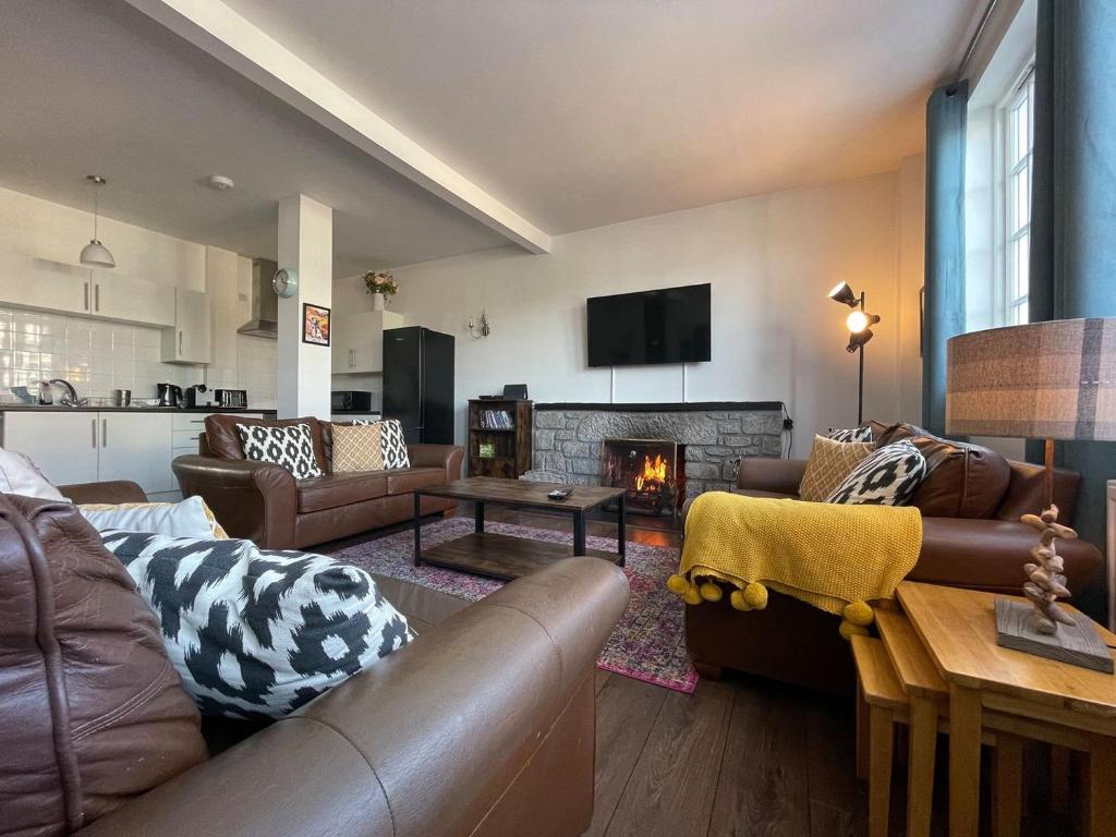 a living room with leather furniture and a fireplace at Seafield Lodge in Grantown on Spey