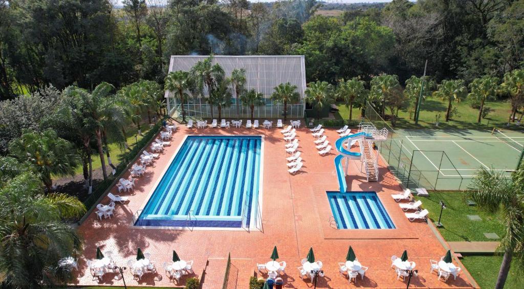 uma vista aérea para uma piscina com cadeiras e um campo de ténis em Hotel Nacional Inn Foz do Iguaçu em Foz do Iguaçu