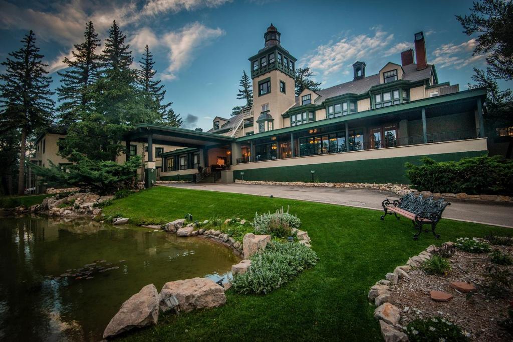 a large house with a pond in front of it at The Lodge at Cloudcroft in Cloudcroft