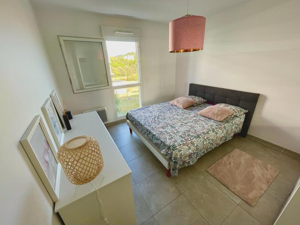 a bedroom with a bed and a table and a window at Appartement coquet in Marseille
