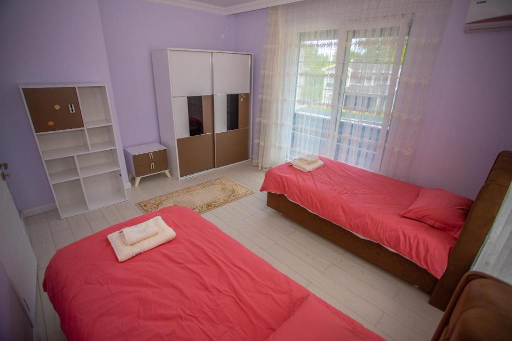una camera con 2 letti rossi e uno specchio di Antonelya Home a Sapanca