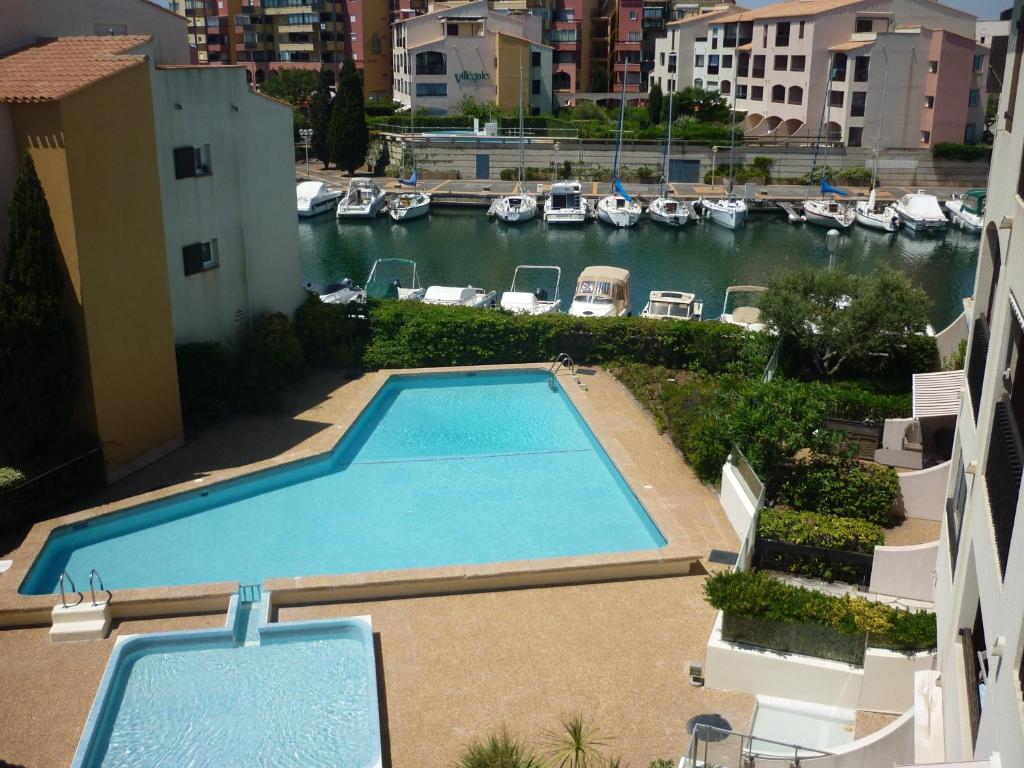 una vista aérea de una piscina con barcos en el agua en Residence des Pecheurs, en Cap d'Agde