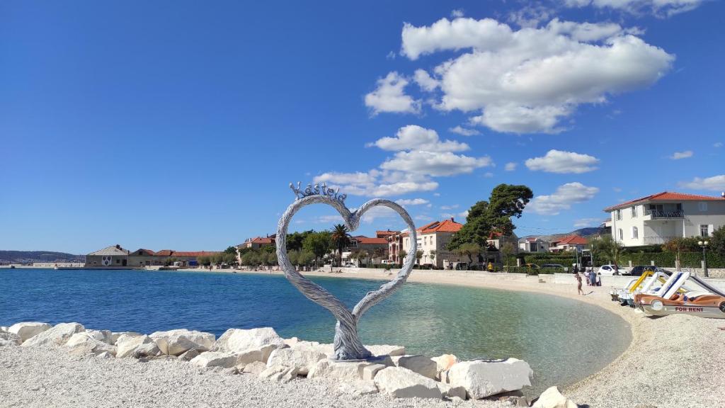 a metal sculpture in the water next to a beach at Apartman Iva in Kaštela