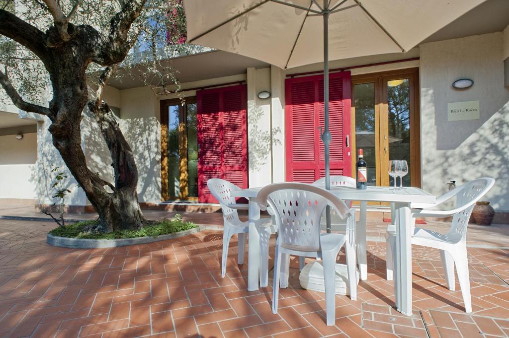 un tavolo e sedie con ombrellone su un patio in mattoni di B&B La Rocca a San Miniato