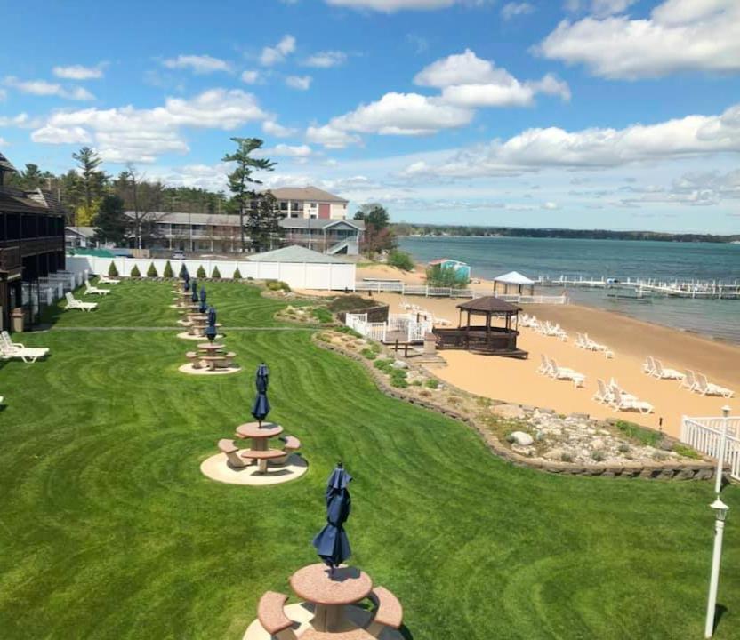 a view of a beach with people sitting on the sand at The Beach Haus - Traverse City in Traverse City
