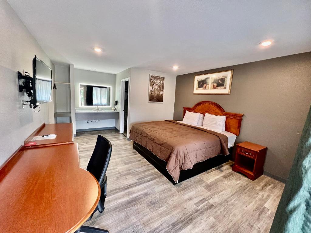 Habitación de hotel con cama y escritorio en Ozark Inn & Suites, en Ozark