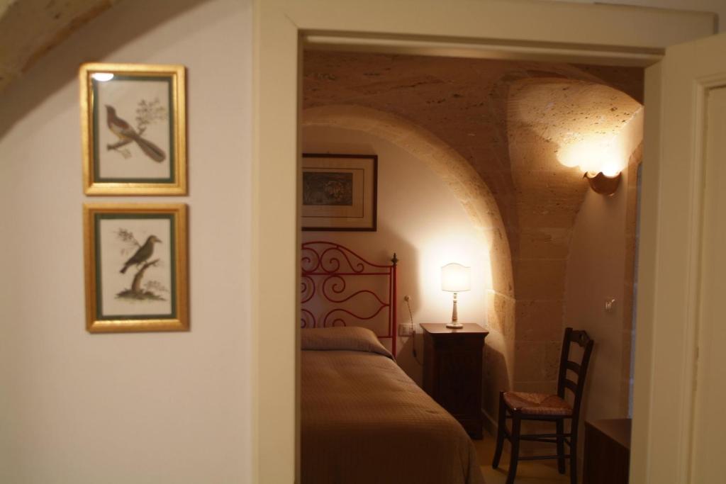 マンドゥーリアにあるB&B Archidamoのベッドルーム1室(ベッド1台付)が備わります。壁に2枚の写真が飾られています。