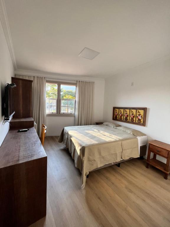 een slaapkamer met een groot bed en een raam bij Pousada Tiradentes in Tiradentes