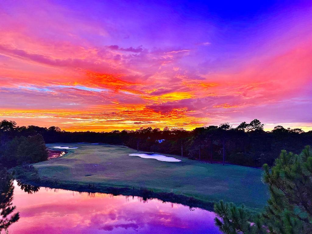 un tramonto su un campo da golf con laghetto di Caddyshack Condo a Big Blackjack Landing