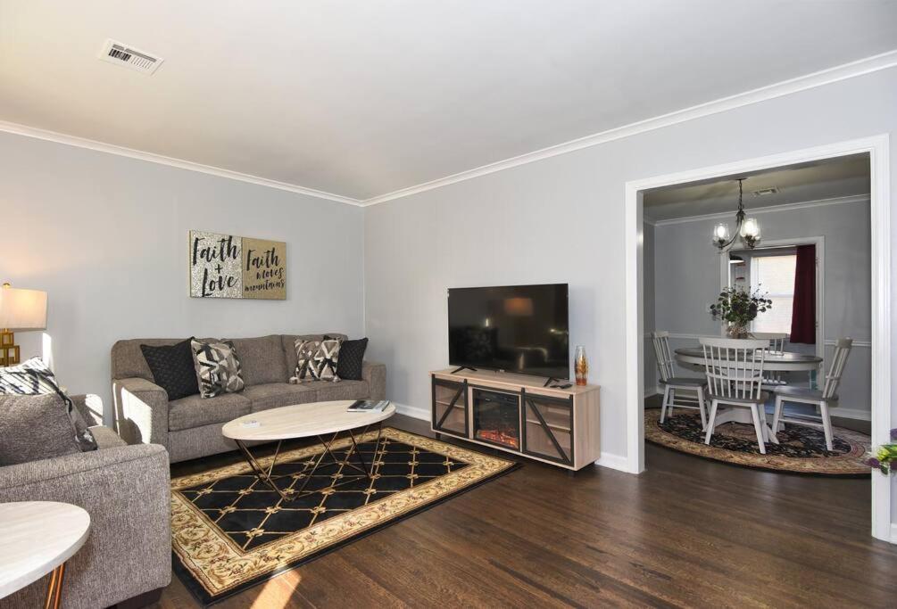 a living room with a couch and a tv and a table at BLUE FLAMINGO'S CHARMING HOME-Heart of Tulsa2- Cherry St-Expo-11th in Tulsa